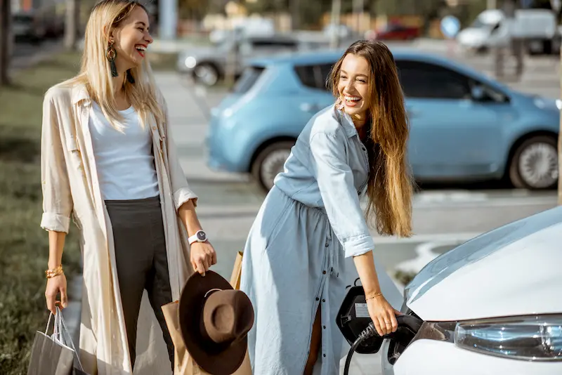 Mujeres cargando su coche eléctrico con Plan Moves 3