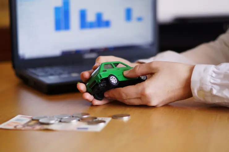 coche-juguete-dinero-ordenador Una mesa con un coche de juguete, dinero y un ordenador
