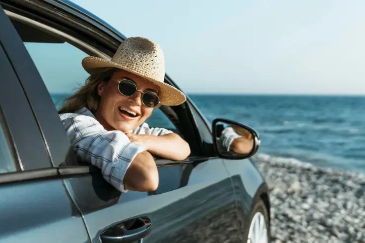 coche-playa Mujer en la ventanilla de su coche de segunda mano