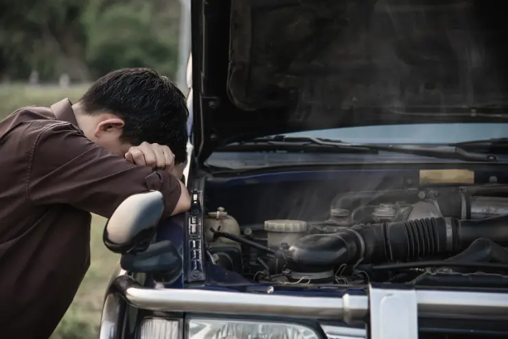 Hombre con un coche usado averiado