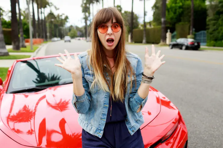 Mujer sorprendida sentada en su coche de ocasión