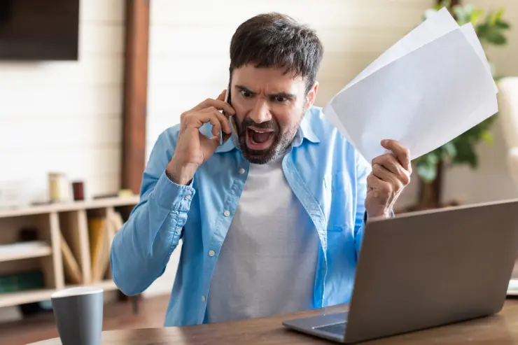 Hombre enfadado con una multa de tráfico en la mano