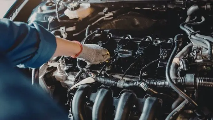 Mecáncio revisando un coche Mecánico realizando la revisión