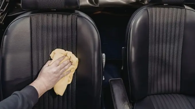 Persona limpiando la tapicería del coche