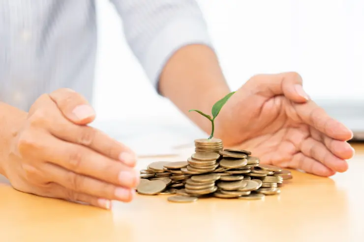 Monedas en una mesa rodeada de unas manos