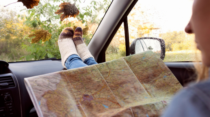 mujer con un mapa de ruta en su furgoneta seminueva