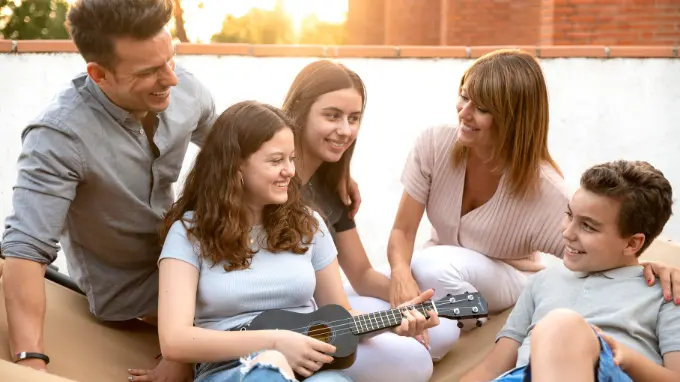Familia numerosa reunida junto a un ukelele